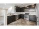 Modern kitchen with dark cabinetry, stainless steel appliances, and tile flooring at 3158 Teaderman Walk, Henderson, NV 89044