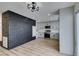 Open living space with black brick accent wall and views into kitchen with light grey cabinets at 341 Greenbriar Townhouse Way, Las Vegas, NV 89121