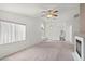 Open living room featuring neutral carpet, ceiling fan, and a fireplace at 3643 Spring Willow Ct, Las Vegas, NV 89147