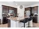 Modern kitchen features dark cabinets, granite counters, a large island, and stainless steel appliances at 369 Monique Springs St, Henderson, NV 89014