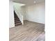 Open-concept living room with stairs, wood-look tile flooring and natural light at 3805 Carisbrook Dr, North Las Vegas, NV 89081