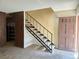 Inviting entryway with a staircase featuring a modern black railing and view of the front door at 3967 Visby Ln, Las Vegas, NV 89119