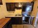 Kitchen features dark cabinetry, laminate countertops, stove, single-basin sink, and tile flooring at 3967 Visby Ln, Las Vegas, NV 89119