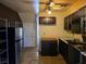 View of the kitchen with dark cabinets, a refrigerator, open shelving, and access to a staircase at 3967 Visby Ln, Las Vegas, NV 89119