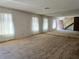 Spacious living room with neutral carpet, large windows, a wall mirror, and a view of the staircase at 3967 Visby Ln, Las Vegas, NV 89119
