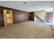 Living room with neutral carpet, wood-paneled wall, view of the staircase and a laundry room at 3967 Visby Ln, Las Vegas, NV 89119