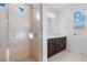 Modern bathroom featuring a glass-enclosed shower and double vanity with dark wood cabinets at 400 S Jena St, Henderson, NV 89015