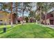 Exterior shot of the apartment buildings with a green space and tall shade trees at 4050 Pacific Harbors Dr # 233, Las Vegas, NV 89121