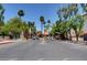 Gated community entrance with lush landscaping and palm trees against a bright sky at 4050 Pacific Harbors Dr # 233, Las Vegas, NV 89121