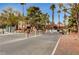 Gated community entrance with lush landscaping and palm trees against a bright sky at 4050 Pacific Harbors Dr # 233, Las Vegas, NV 89121