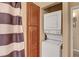 A laundry area with a stacked washer and dryer, and storage cabinets at 4050 Pacific Harbors Dr # 233, Las Vegas, NV 89121