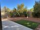 Lush backyard featuring a low-maintenance landscape design and a large concrete patio at 4912 Capo Gallo St, Las Vegas, NV 89130