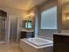 Bathroom with soaking tub, walk-in shower, and vanity with a large mirror at 4912 Capo Gallo St, Las Vegas, NV 89130