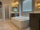 Bathroom featuring a large soaking tub, walk-in shower, and vanity with large mirror at 4912 Capo Gallo St, Las Vegas, NV 89130