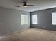 Spacious bedroom featuring neutral carpet, three windows, and a ceiling fan at 4912 Capo Gallo St, Las Vegas, NV 89130