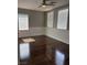 Bedroom featuring a ceiling fan, three windows, and glossy hardwood flooring at 4912 Capo Gallo St, Las Vegas, NV 89130