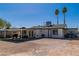 Backyard view of a house featuring a patio and palm trees set against a clear, sunny sky at 5582 Tunis Ave, Las Vegas, NV 89122