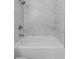 Bathroom featuring stone-style walls, bathtub with shower, and chrome faucet at 5582 Tunis Ave, Las Vegas, NV 89122