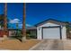 Exterior of a home with a two-car garage, gravel landscaping, palm trees, and a covered parking area at 5582 Tunis Ave, Las Vegas, NV 89122