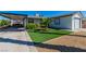 Front yard featuring a well-maintained lawn, lush bushes, gravel landscaping, and a covered parking area at 5582 Tunis Ave, Las Vegas, NV 89122