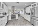 Modern kitchen featuring white cabinets, stainless steel appliances, and wood-look flooring at 5582 Tunis Ave, Las Vegas, NV 89122