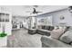 Open concept living room featuring a comfortable gray couch, modern ceiling fan, and wood-look floors at 5582 Tunis Ave, Las Vegas, NV 89122