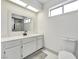 Bright bathroom featuring white cabinets, a large mirror, and a view of the walk-in shower at 5815 Christchurch Ave, Las Vegas, NV 89110