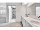 Bathroom with double sinks, white cabinets and a view of the modern stone tile shower at 5815 Christchurch Ave, Las Vegas, NV 89110