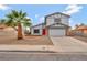 Two-story home featuring desert landscaping, an attached two-car garage, and a red front door at 5815 Christchurch Ave, Las Vegas, NV 89110