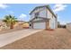 Two-story home with a spacious driveway, two-car garage, and desert landscaping at 5815 Christchurch Ave, Las Vegas, NV 89110