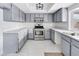 Modern kitchen with gray cabinets, stainless steel appliances, and white countertops at 5815 Christchurch Ave, Las Vegas, NV 89110