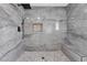 Modern shower featuring gray stone tile, a built-in bench, and a rainfall shower head at 5815 Christchurch Ave, Las Vegas, NV 89110