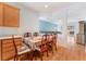 Cozy dining area with wood-style flooring and seating for six, flowing into the adjacent living space at 5991 Saddle Horse Ave, Las Vegas, NV 89122