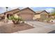 Inviting single-story home featuring a two-car garage, desert landscaping, and a spacious driveway at 5991 Saddle Horse Ave, Las Vegas, NV 89122