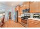 Efficient kitchen layout featuring stainless steel appliances, ample cabinet space, and wood-style flooring at 5991 Saddle Horse Ave, Las Vegas, NV 89122