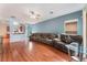 Bright living room featuring wood floors, a ceiling fan, and a comfortable oversized sofa with pillows at 5991 Saddle Horse Ave, Las Vegas, NV 89122