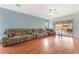 Bright living room features wood floors, a ceiling fan, and sliding doors leading to the backyard at 5991 Saddle Horse Ave, Las Vegas, NV 89122