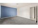 Bedroom with neutral carpet, blue accent wall, and an open doorway leading to the bathroom at 6155 W Twain Ave, Las Vegas, NV 89103
