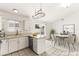 Bright kitchen features white cabinets, stainless steel appliances, and a dining area with pool view at 6155 W Twain Ave, Las Vegas, NV 89103
