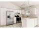 Bright kitchen with stainless steel refrigerator, white cabinets and tile countertops at 6155 W Twain Ave, Las Vegas, NV 89103