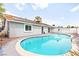 Inviting backyard pool with clear blue water, surrounded by a concrete patio and a white stucco wall at 6155 W Twain Ave, Las Vegas, NV 89103