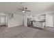 Open concept living space with stainless steel appliances, grey carpet and wood grain vinyl flooring at 6246 Blood Lily Ave, Las Vegas, NV 89122