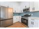 Bright kitchen features stainless steel appliances, ample white cabinetry, and stylish backsplash at 629 Majestic Sky Dr, North Las Vegas, NV 89031