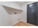 Small laundry room with shelving, a black door, and a light wood-look floor at 629 Majestic Sky Dr, North Las Vegas, NV 89031