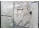 Modern shower featuring a glass door, sleek fixtures, and stylish marble-patterned tile surround with built-in niche at 629 Majestic Sky Dr, North Las Vegas, NV 89031