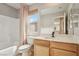 Bathroom with a tub/shower combo, wooden vanity and neutral countertops, offering functionality and style at 6622 Palm Branch St, North Las Vegas, NV 89086