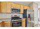 Close up of the kitchen featuring stainless appliances, granite countertops and blonde wood cabinetry at 6622 Palm Branch St, North Las Vegas, NV 89086