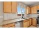 Modern kitchen featuring granite countertops, subway tile backsplash, and stainless steel appliances at 6622 Palm Branch St, North Las Vegas, NV 89086