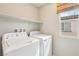 Bright laundry room features a window and includes a washer and dryer for added convenience at 6622 Palm Branch St, North Las Vegas, NV 89086