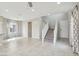 Spacious living room featuring tile flooring, large windows, and an open staircase to the second floor at 6622 Palm Branch St, North Las Vegas, NV 89086
